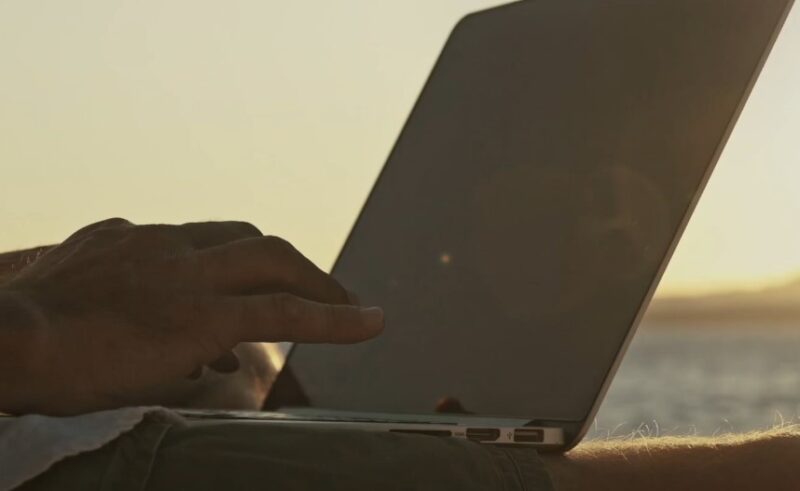 Close up view of a man's fingers typing on laptop keyboard