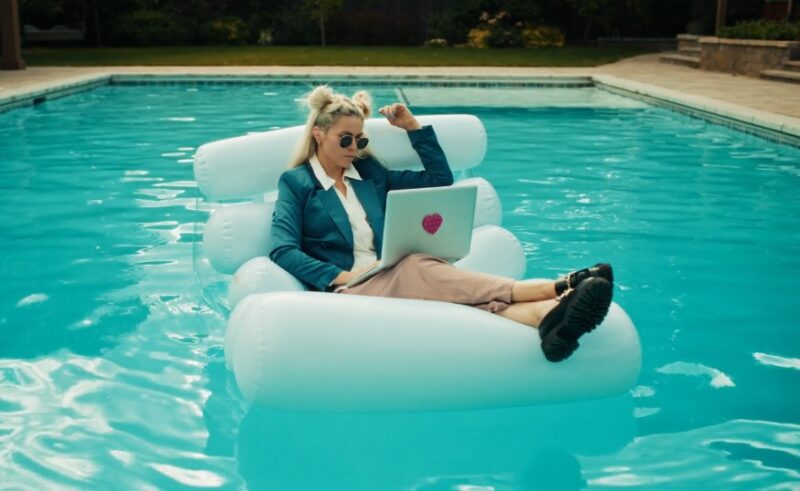 A woman sitting in an inflatable chair in the middle of a swimming pool